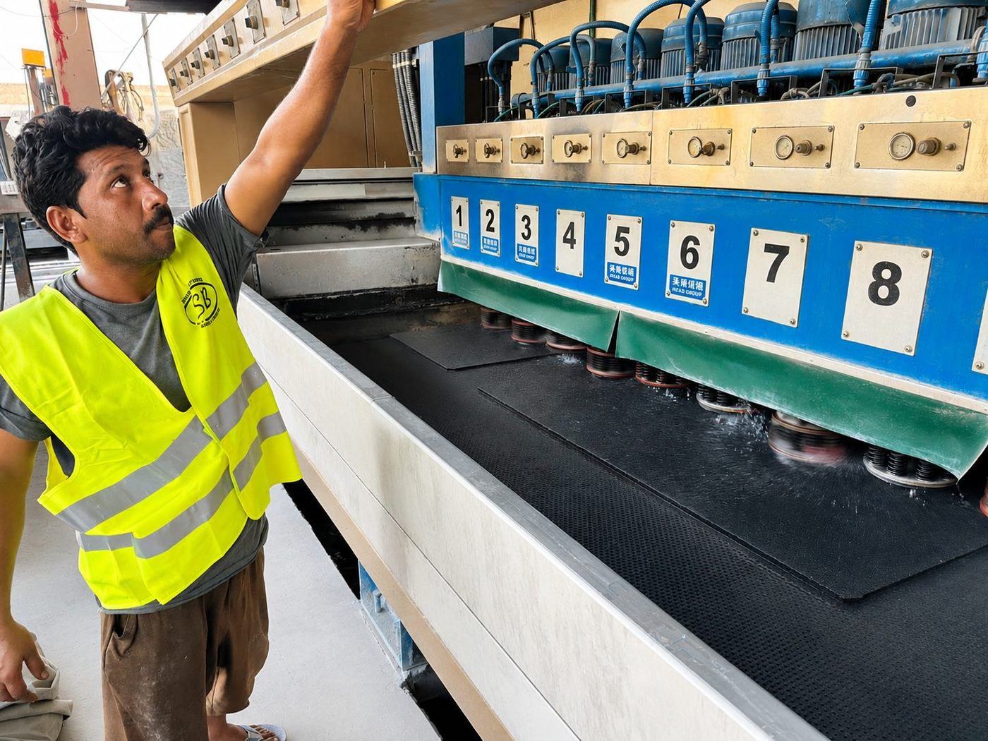 Technician overseeing the multi-head slab polishing machine